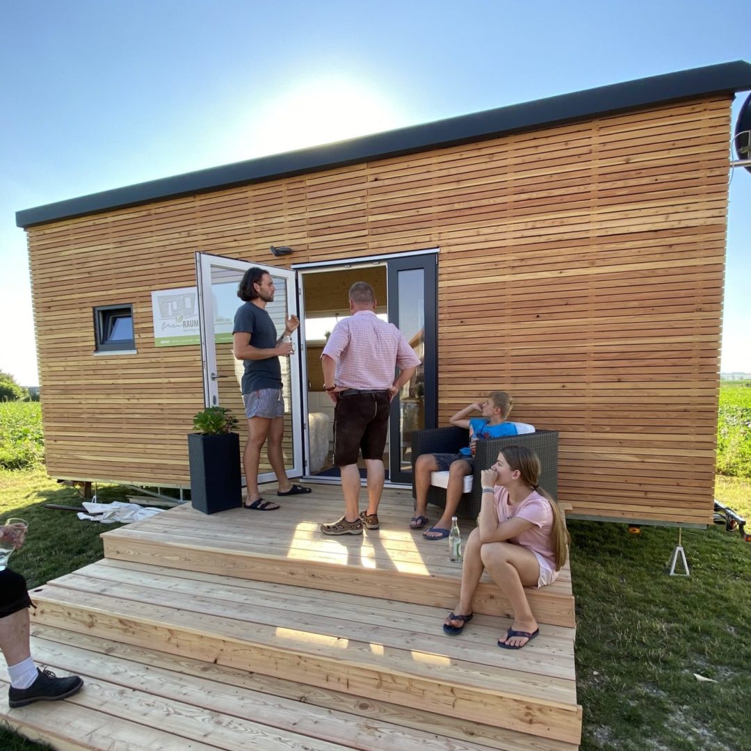 Tiny House mit Besuchern auf der Terrasse